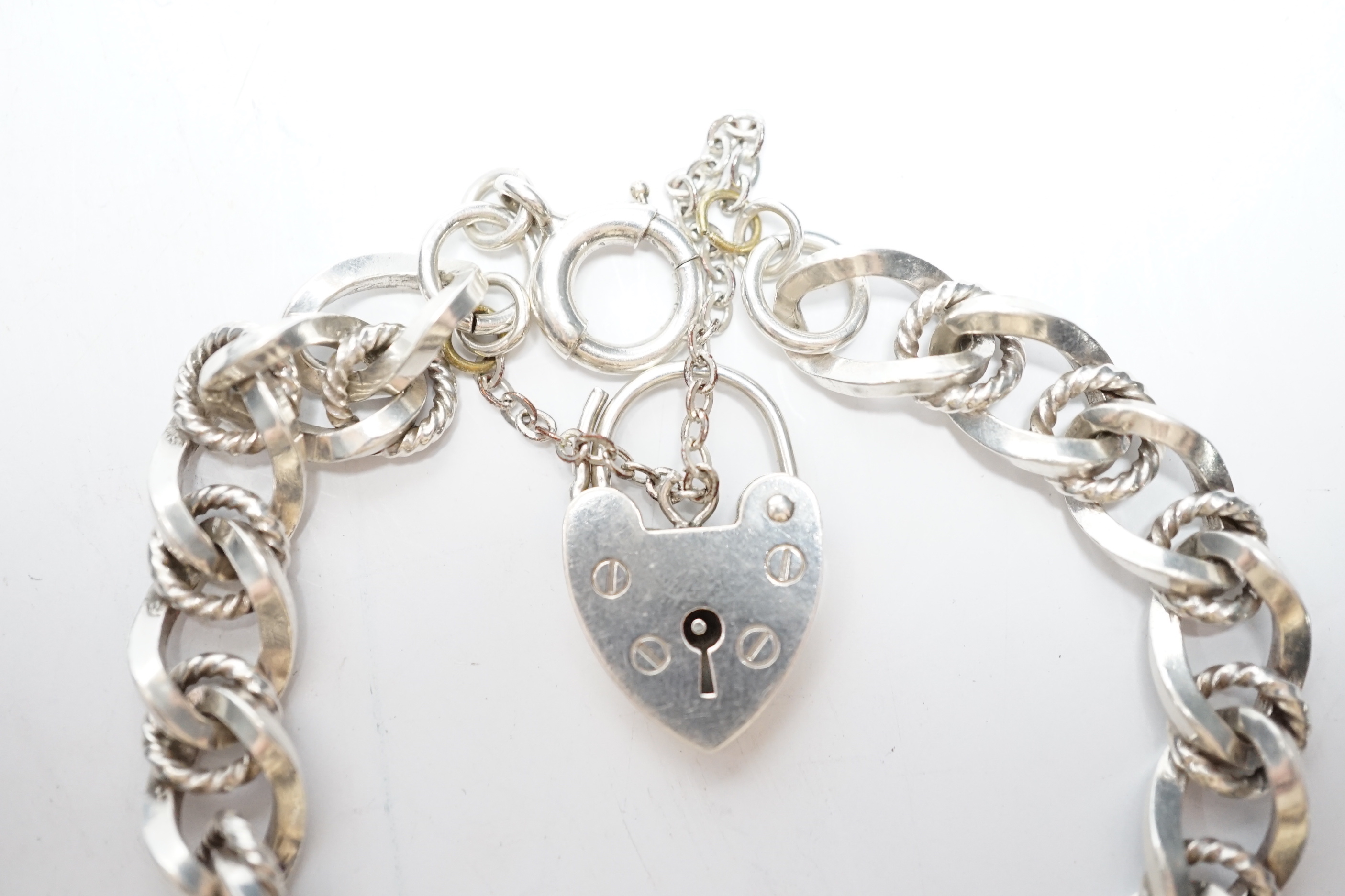A modern silver curb and rope twist link bracelet, with heart shaped padlock clasp, 18cm.